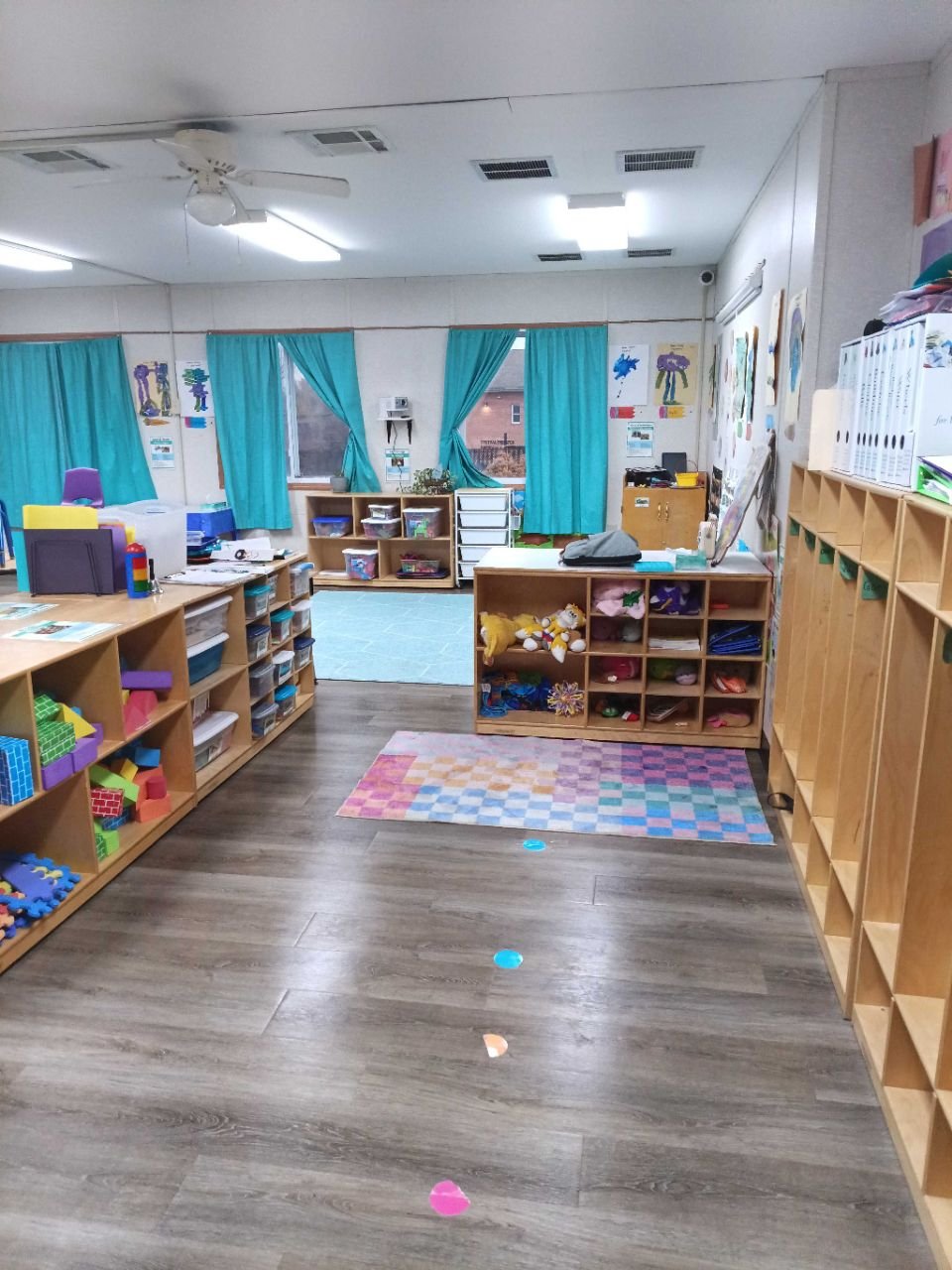 clean and organized daycare classroom with toys shelves and play area